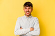 © Asier - Young caucasian man isolated on yellow background who feels confident, crossing arms with determination.