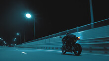 A Man Rides A Sports Motorcycle On A Night Track