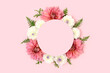 Wreath made of dahlia and green leaves on a pink background. Flower round frame with copyspace.