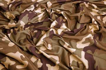 Wall Mural - close up of the camouflage textured fabric wavy background