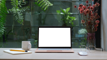Wall Mural - computer laptop with empty display, coffee cup, pencil holder and houseplant on wooden table..