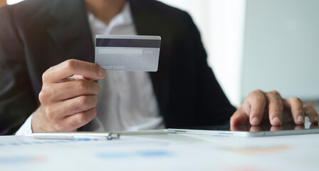 Man holding credit card and using digital tablet. Online shopping, e-commerce, internet banking