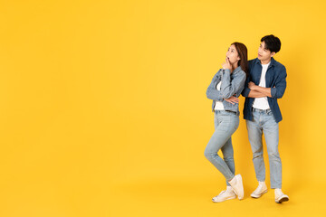 Wall Mural - Two Young good looking asian couple using isolated on yellow background presenting to copy space feeling excited
