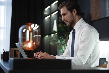 Wall Mural - Portrait of young pensive man sitting at his desk in the office.