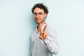 Young caucasian man isolated on blue background showing number two with fingers.