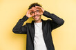 © Asier - Young caucasian man isolated on yellow background showing okay sign over eyes