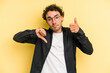 © Asier - Young caucasian man isolated on yellow background showing thumbs up and thumbs down, difficult choose concept