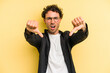 © Asier - Young caucasian man isolated on yellow background showing thumb down and expressing dislike.