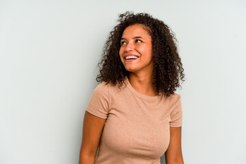 Wall Mural - Young Brazilian woman isolated on blue background relaxed and happy laughing, neck stretched showing teeth.