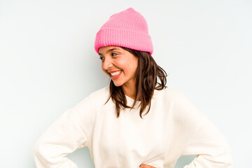 Wall Mural - Young hispanic woman isolated on blue background looking sideways with doubtful and skeptical expression.