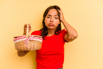 Wall Mural - Young hispanic woman going to do it picnic isolated on yellow background being shocked, she has remembered important meeting.