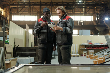 Poster - Two young male engineers of large modern factory discussing presentation of new building materials at working meeting