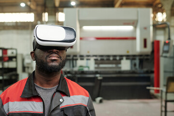Aufkleber - Young serious African American male engineer in vr headset making presentation of industrial equipment while standing in workshop