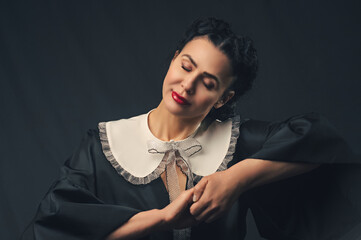 sweet tender woman in black dress with white collar.