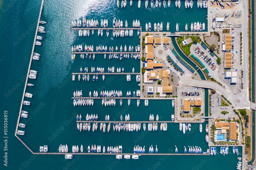 Aerial top view of a lot of white boats and yachts moored in marina. Top-down view of docked sailboats. Top down view of yachts. Luxury yacht Boat in a port. Marina lot sailboat. Harbour with boats