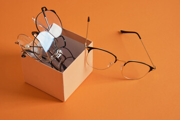 Poster - eye glasses on gift box orange background copy space