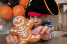 A Boy Dressed As A Pirate Eats Skeletal Gingerbread On Halloween And Plays With Cookies