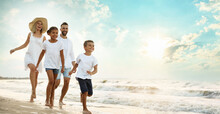 Happy Family Walking On Sandy Beach Near Sea At Sunset, Space For Text. Banner Design