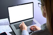 © insta_photos - Young female ceo executive manager using typing writing email letter using pc laptop computer with empty blank white screen for advertising at desk. Business technologies concept. Over shoulder view.