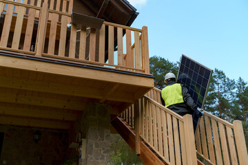 Wall Mural - Man worker carrying solar panel for installing solar modul system on house.