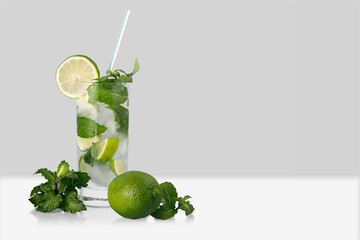 Poster - Organic cold refreshing lemonade drink or cocktail made of sparkling water, lime slices and fresh green mint leaves served in drinking glass with ice cubes