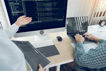 Wall Mural - two software developers are analyzing together about the code written into the program on the comput