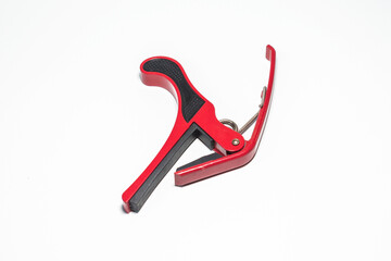 red capo for guitar isolated on white background