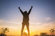 © Panumas - Silhouette of woman runner standing and open arm celebrate her success with healthy at the road track with sunset background.