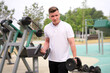 © Евгений Шемякин - portrait of handsome happy strong athletic man athlete bodybuilder training with dumbbells outdoors at open air gym at summer, gain hands and shoulders muscles. Bodybuilding fitness, healthy lifestyle