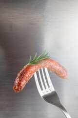 Sticker - Tasty Grilled sausages with rosemary on a fork.