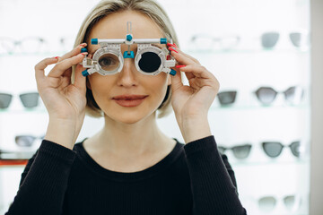 Wall Mural - Woman making a sight diagnostics at optics store