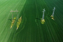 Aerial Shot Of Electricity Pylons And Transmission Towers In Cultivated Agricultural Field