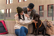 © NFstock - Full length view of the smiling brunette lady hugging pedigree dog on bench while her husband embracing her. Pet care concept