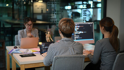 Software developers team brainstorming and programming in co working space