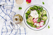 Vegetarian vegetable salad of radish, cucumbers, avocado and yogurt.  Healthy vegan food. Top view, above