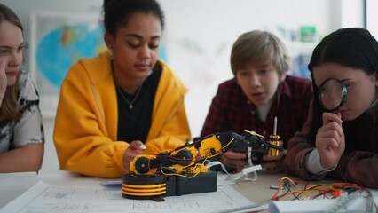 Wall Mural - group of students building and programming electric toys and robots at robotics classroom