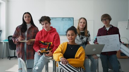 Sticker - Group of students sitting and posing together in robotics classroom