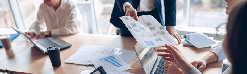 Wall Mural - Close up of business people consider documents with charts in a modern office. Teamwork concept