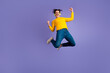 © deagreez - Full body of energetic overjoyed guy jumping raise fists shout yes rejoice isolated on purple color background