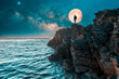 silhouette of person with backpack on the top of the cliff with full moon background over the ocean