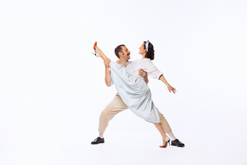 Wall Mural - Portrait of young beautiful couple, man and woman, dancing isolated over white studio background. Twine