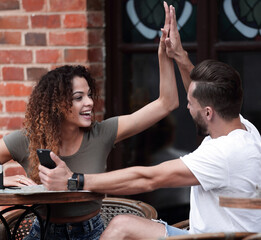 Canvas Print - Portrait of a young couple sitting down at a cafe outside