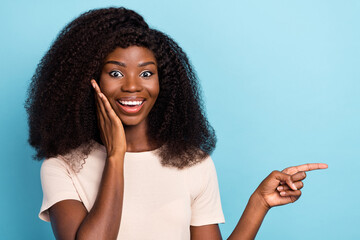 Poster - Photo of excited crazy girl hand touch cheek direct finger empty space offer isolated on blue color background