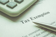 Info about tax exemption with calculator and pen.