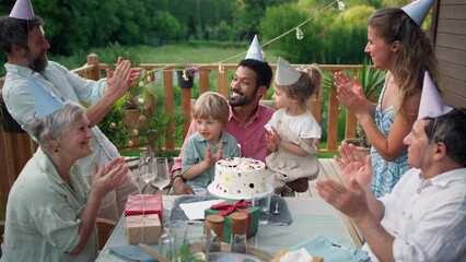 Wall Mural - Multi generation family celebrating birthday and have garden party outside in the backyard on patio.