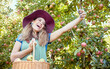 © Jade Maas/peopleimages.com - One happy woman taking selfies and video call on cellphone holding basket of fresh picked apples on sustainable orchard farm outside. Cheerful farmer harvesting juicy organic fruit in season to eat