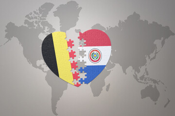 puzzle heart with the national flag of belgium and paraguay on a world map background.Concept.