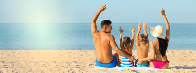 Poster - Happy family on sandy beach near sea, space for text. Banner design