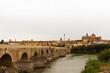 Cordoba, Spain, September 13, 2021: Guadalquivir River and the Roman Bridge, with Cordoba Mosque-Cathedral in the background.