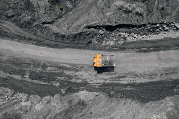 Concept Open pit mine industry, big yellow mining truck for coal, top view aerial drone